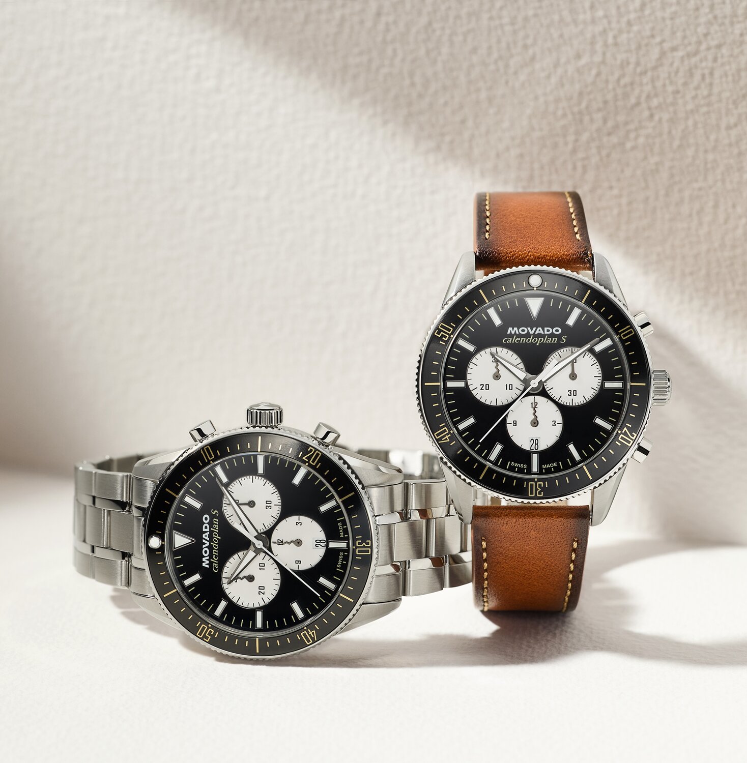 Heritage Calendoplan S watch with stainless steel bracelet and black chronograph dial next to the Heritage Calendoplan S watch with brown leather strap and black chronograph dial.