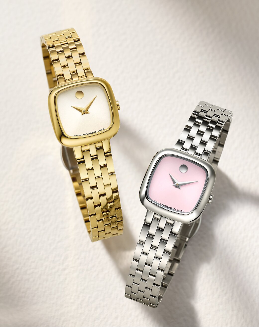 Gold tone Museum Classic watch with square dial next to a stainless steel Museum Classic watch with pink square dial.
