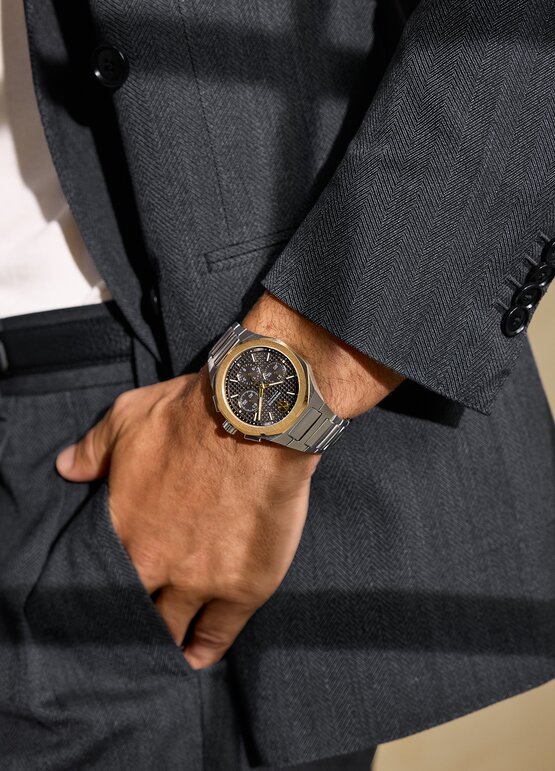 Man in a suit wearing the Two Tone Alta Centurion Chronograph bracelet watch with 18K Gold Bezel.