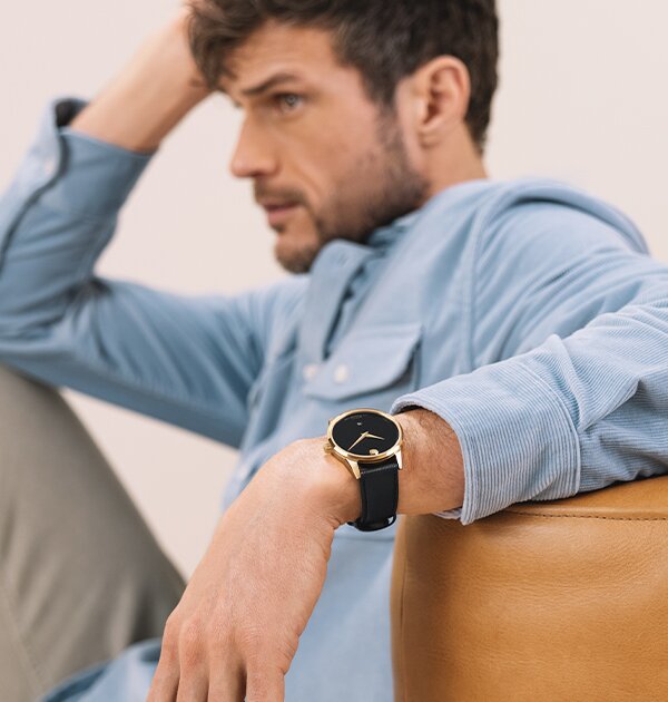 Man in a blue shirt wearing a black Museum Classic leather watch