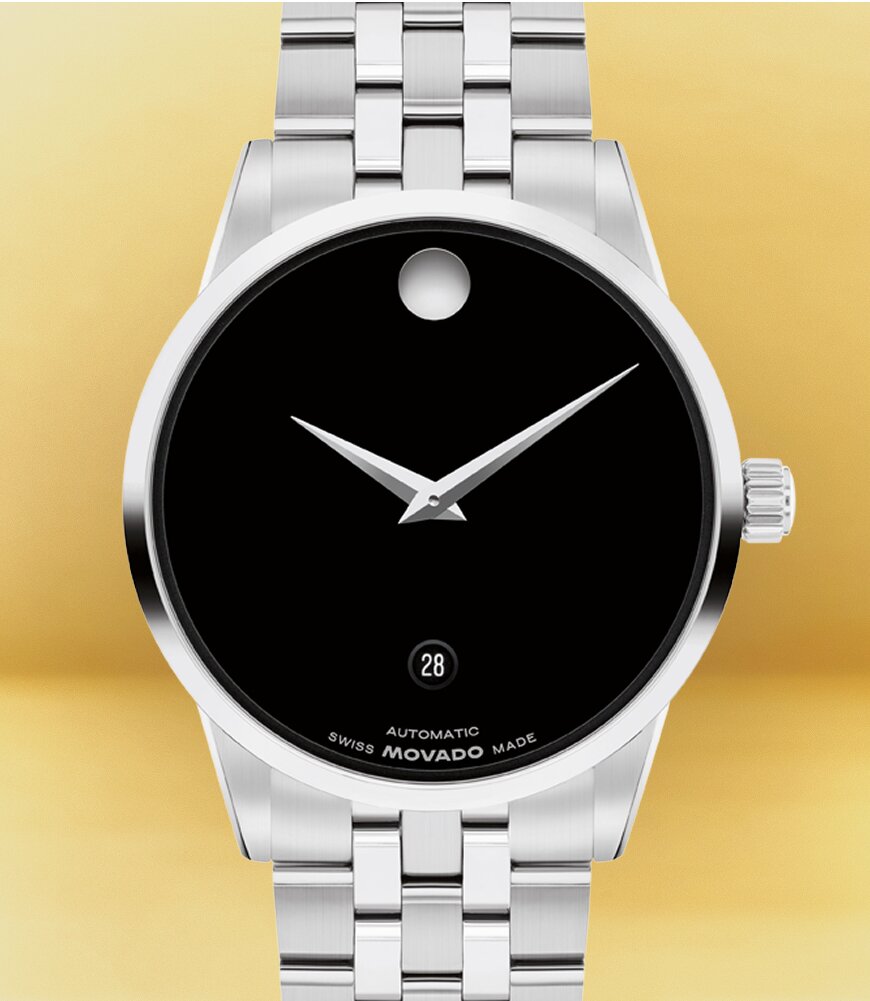 Museum Classic Automatic watch with stainless steel bracelet and black dial in front of a yellow background.