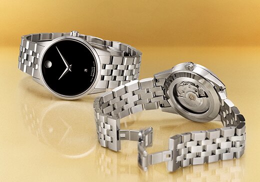 Museum Classic Automatic watch with silver bracelet and black dial next to the back of the watch with an exposed automatic movement case back