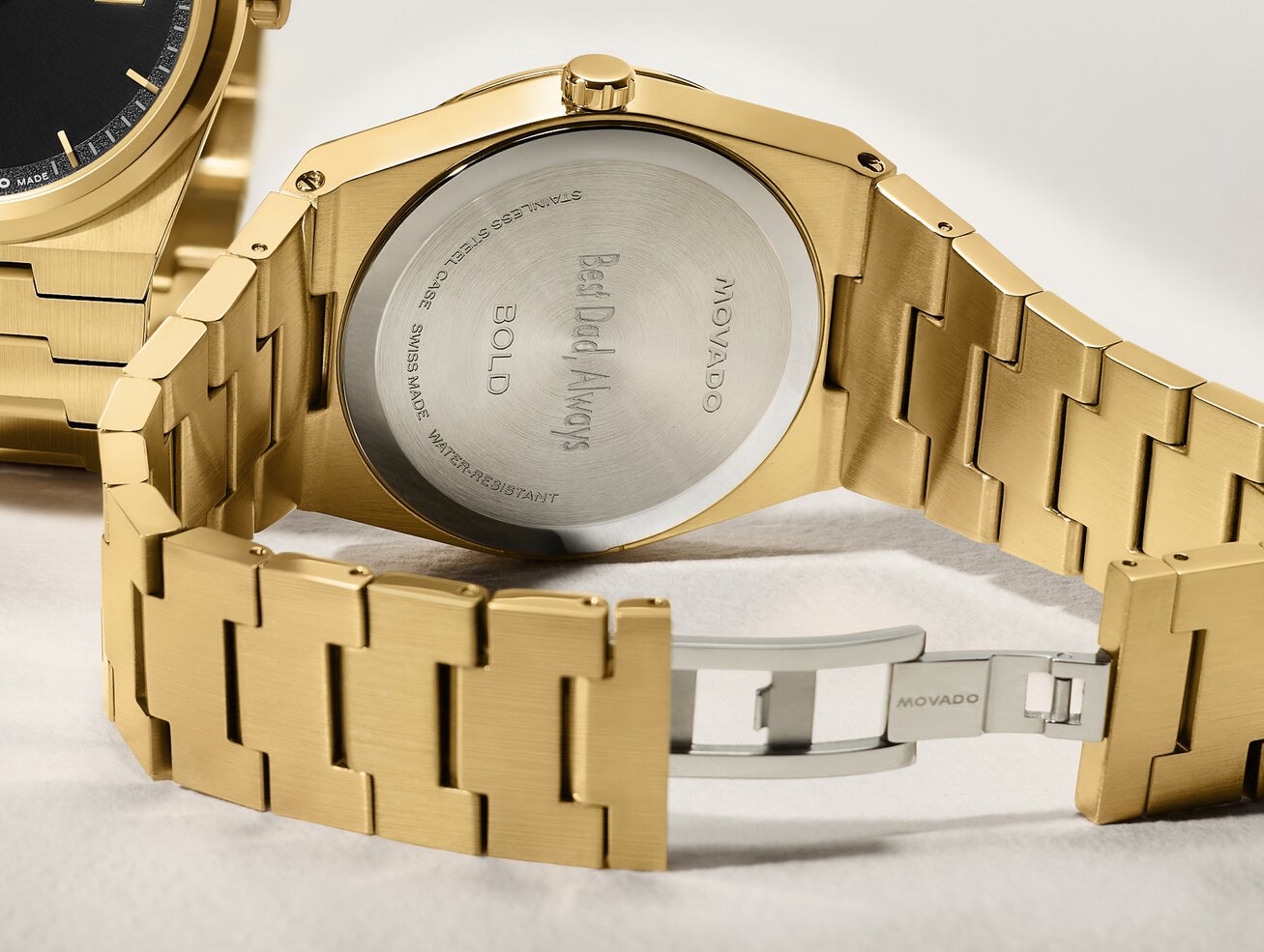 Caseback of gold tone BOLD Quest watch that is engraved with, "Best Dad, Always".