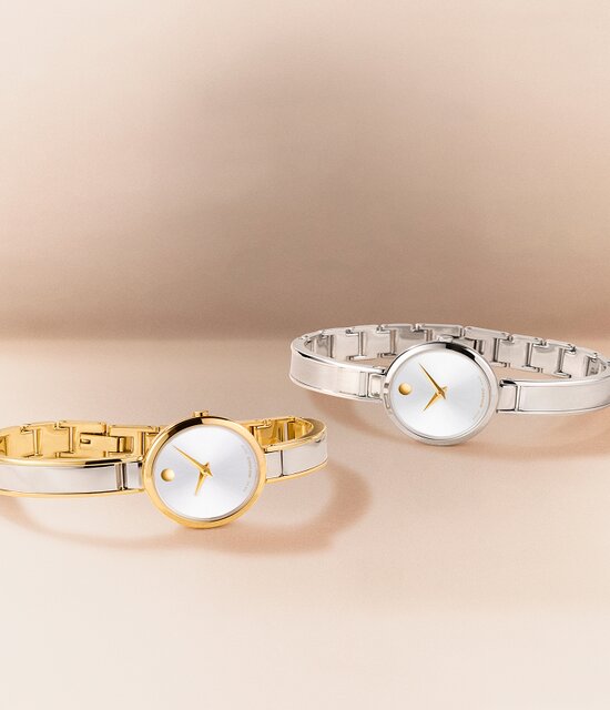 Two tone Moda bangle watch laying in front of a silver Moda bangle watch with gold accents.