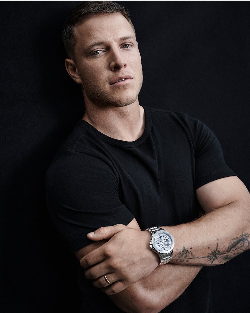 Christian McCaffrey in a black t-shirt with his arms crossed wearing a silver Alta SE Skeleton watch