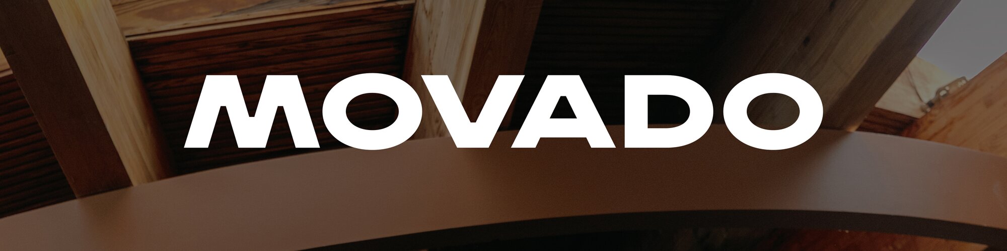 Wooden ceiling panels dimmed behind the movado logo in white