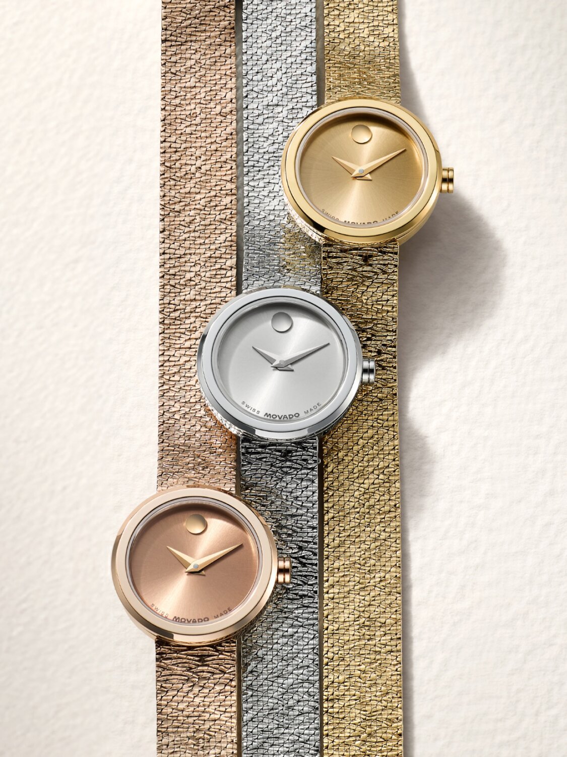 Rose gold tone, stainless steel and gold tone Museum Velura Mini watches laying next to one another.