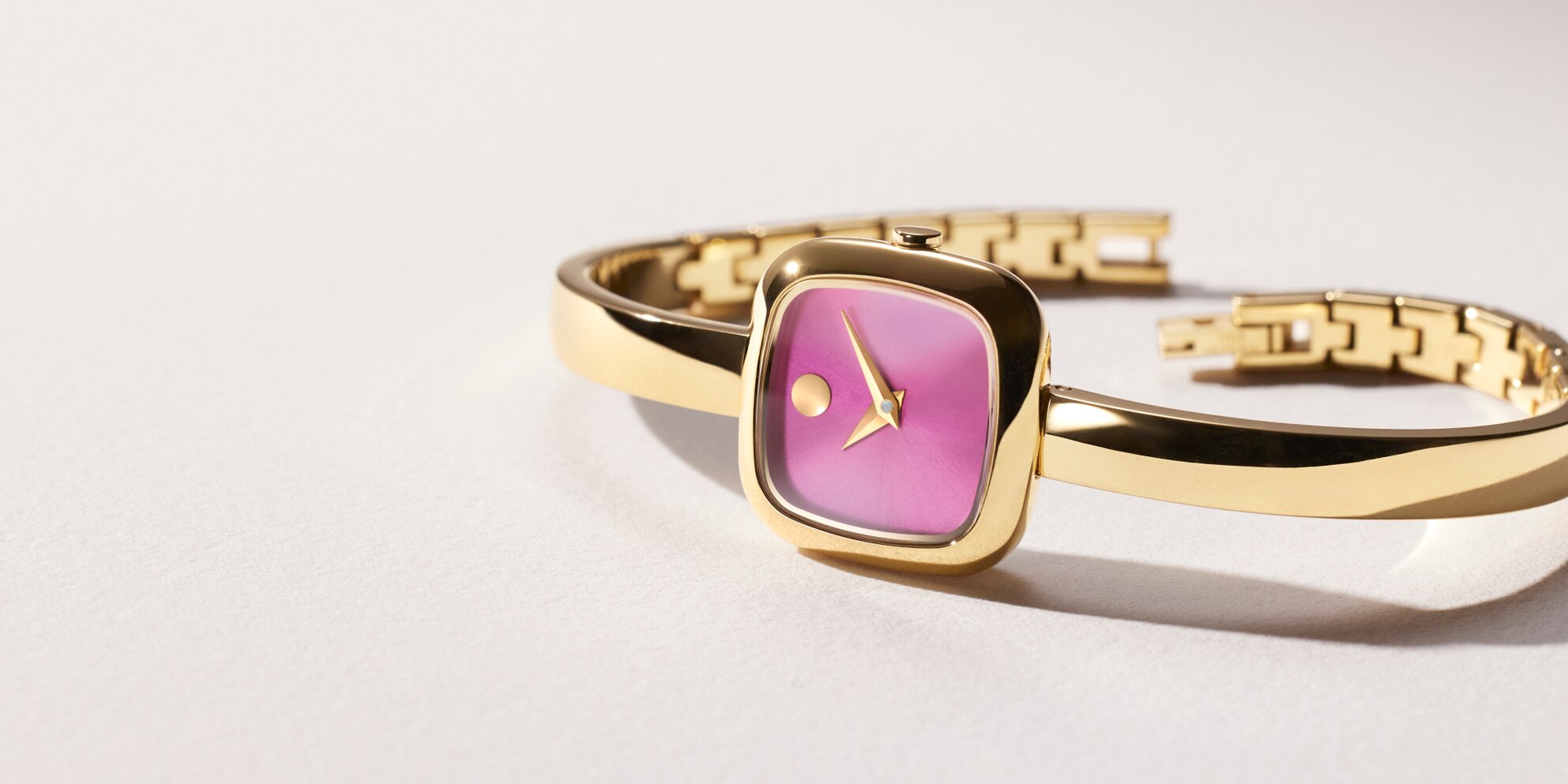 Gold tone Museum Bangle watch with pink square dial.