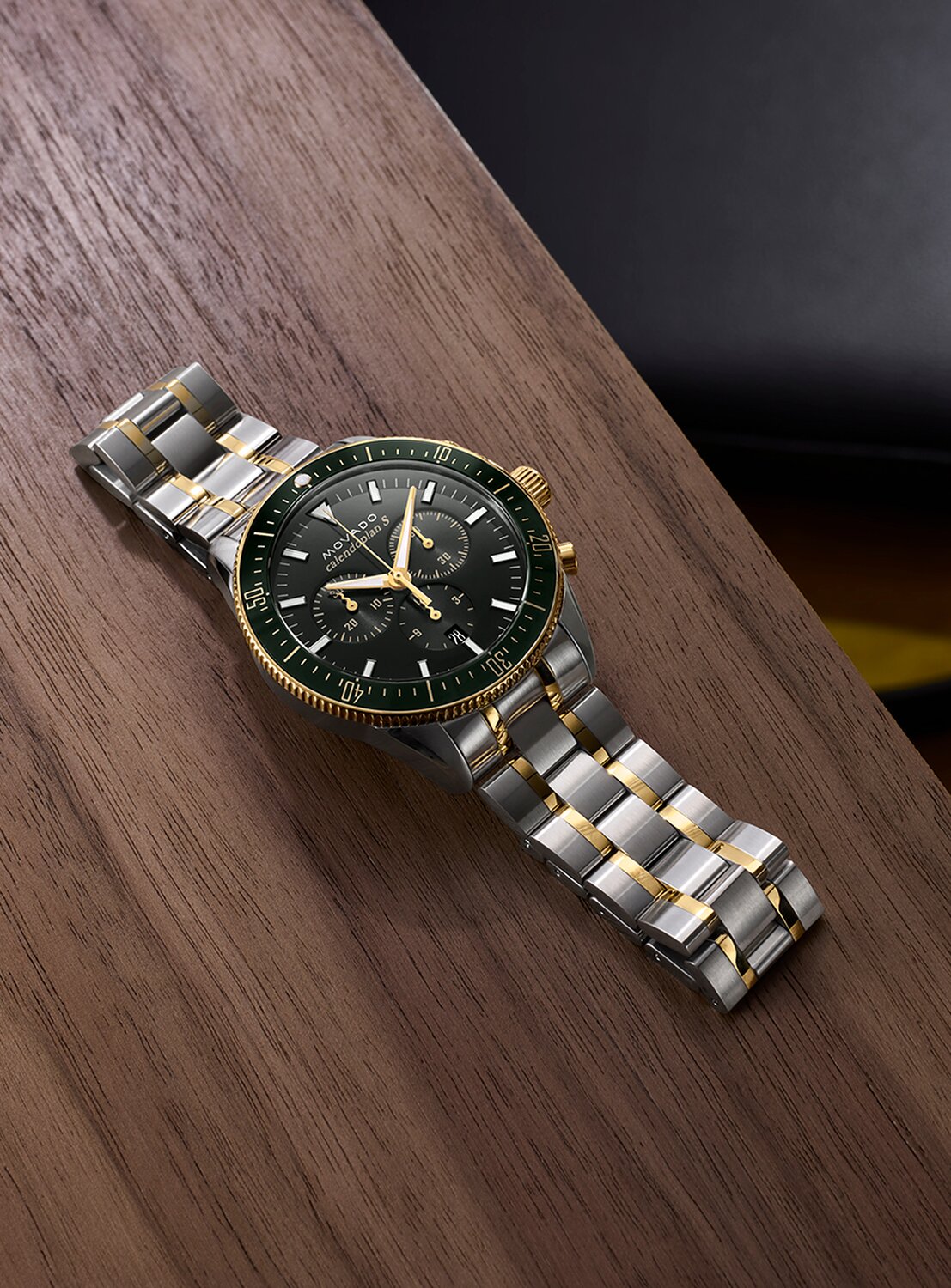 Heritage Series chronograph watch with stainless steel bracelet and green dial laying on a table