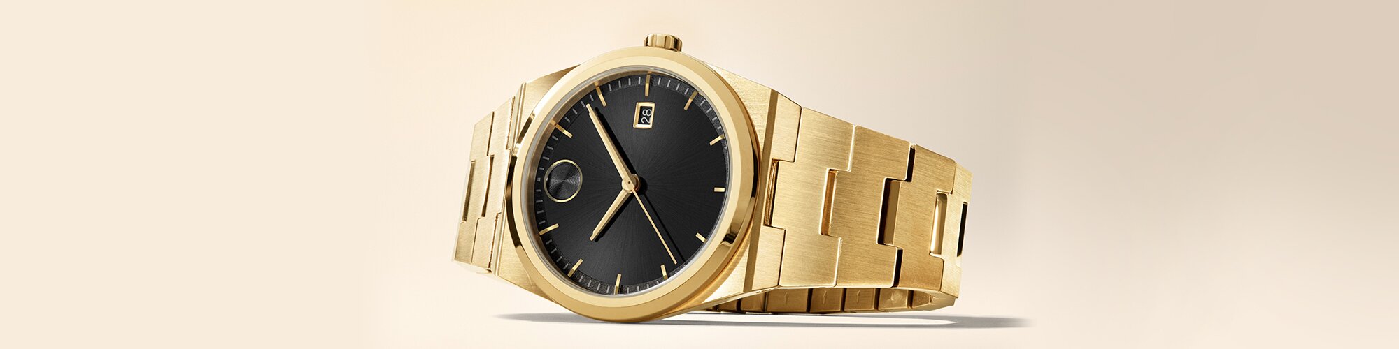 Movado BOLD Quest gold plated bracelet watch with black dial laying on its side