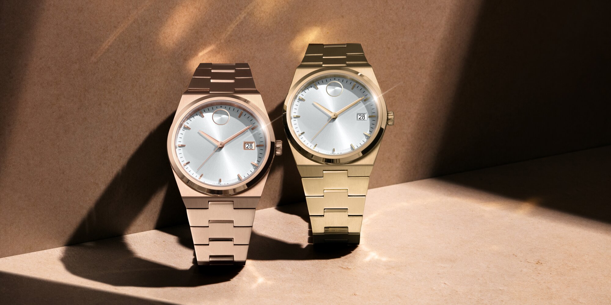 Rose gold tone BOLD Quest watch with white dial next to a gold tone BOLD Quest watch with white dial