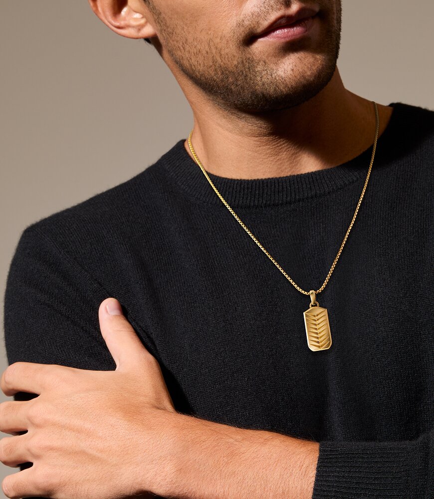Man in a black sweater wearing the gold plated chevron necklace.
