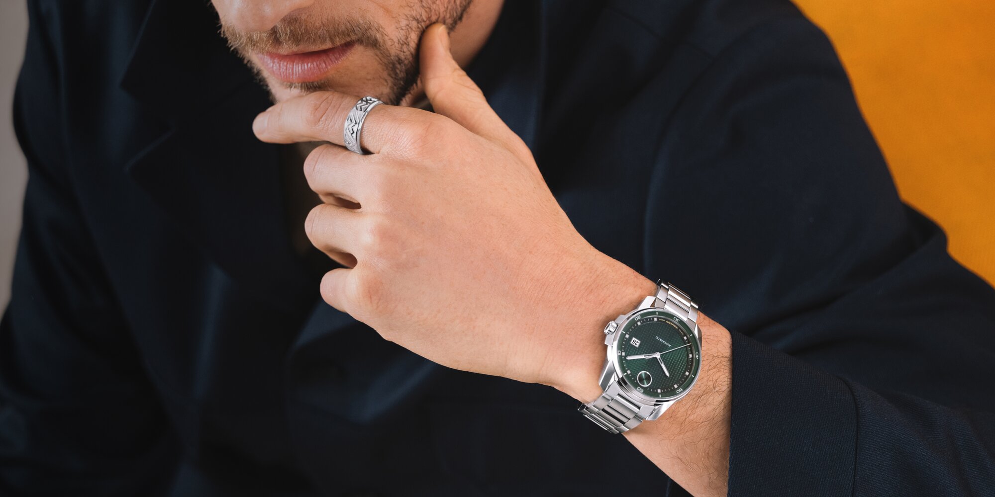 Man in a black sweater wearing the BOLD Verso Automatic watch with stainless steel bracelet and green dial.