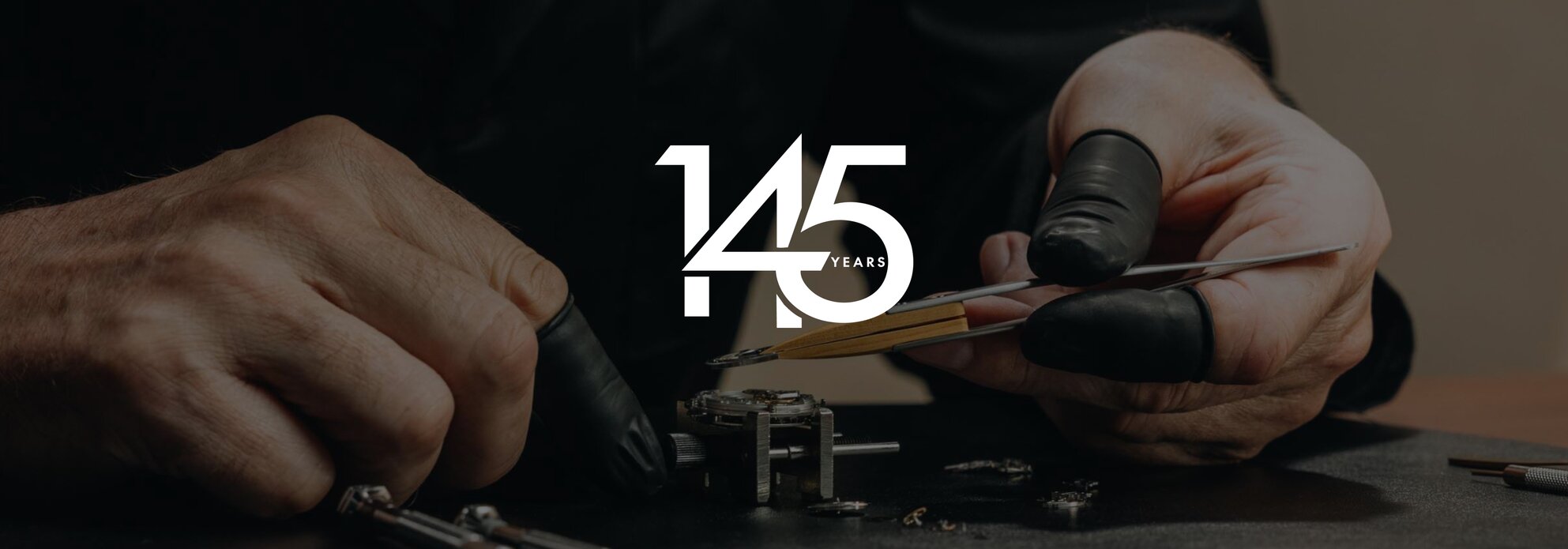 Person putting together an automatic movement with finger gloves. The 145 year Movado logo is on top of the image in white.
