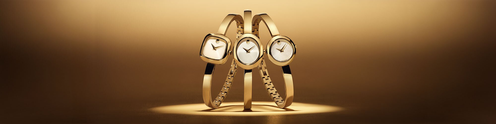 Three gold tone Museum Bangle watches with square, oval and circle dials. 