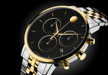 Museum Classic Chronograph watch with two tone bracelet and black dial with gold accents.