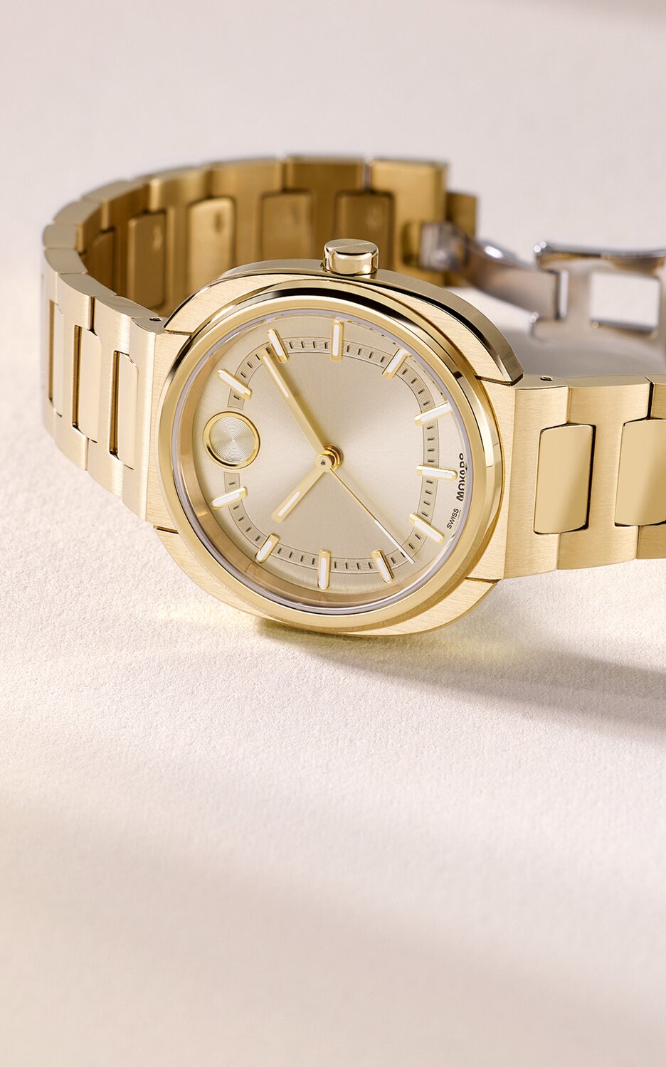 Gold tone BOLD Nuvo bracelet watch laying on its side.
