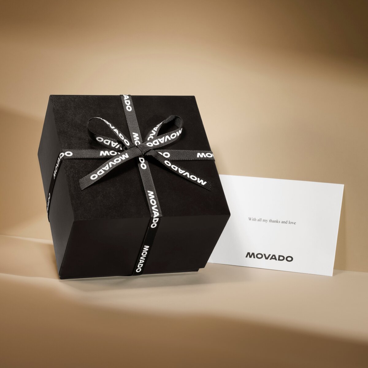 Movado black gift box with branded black ribbon and note card with Movado logo