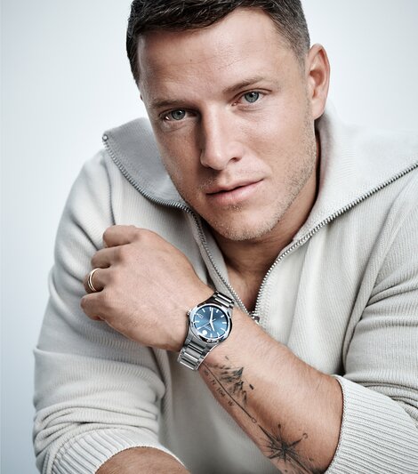 Christian McCaffrey in a quarter zip sweater wearing the stainless steel Museum Imperiale bracelet watch with blue dial