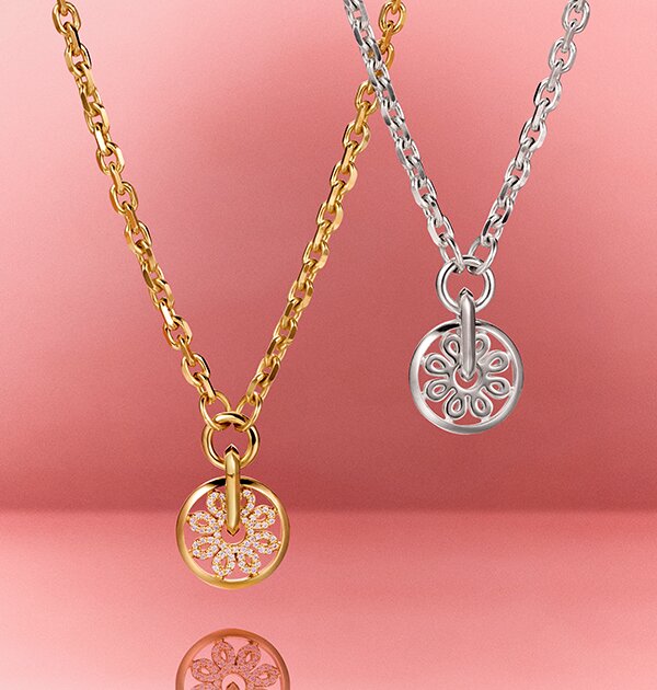 Gold tone necklace with lab grown diamonds and fleur charm next to silver fleur charm necklace