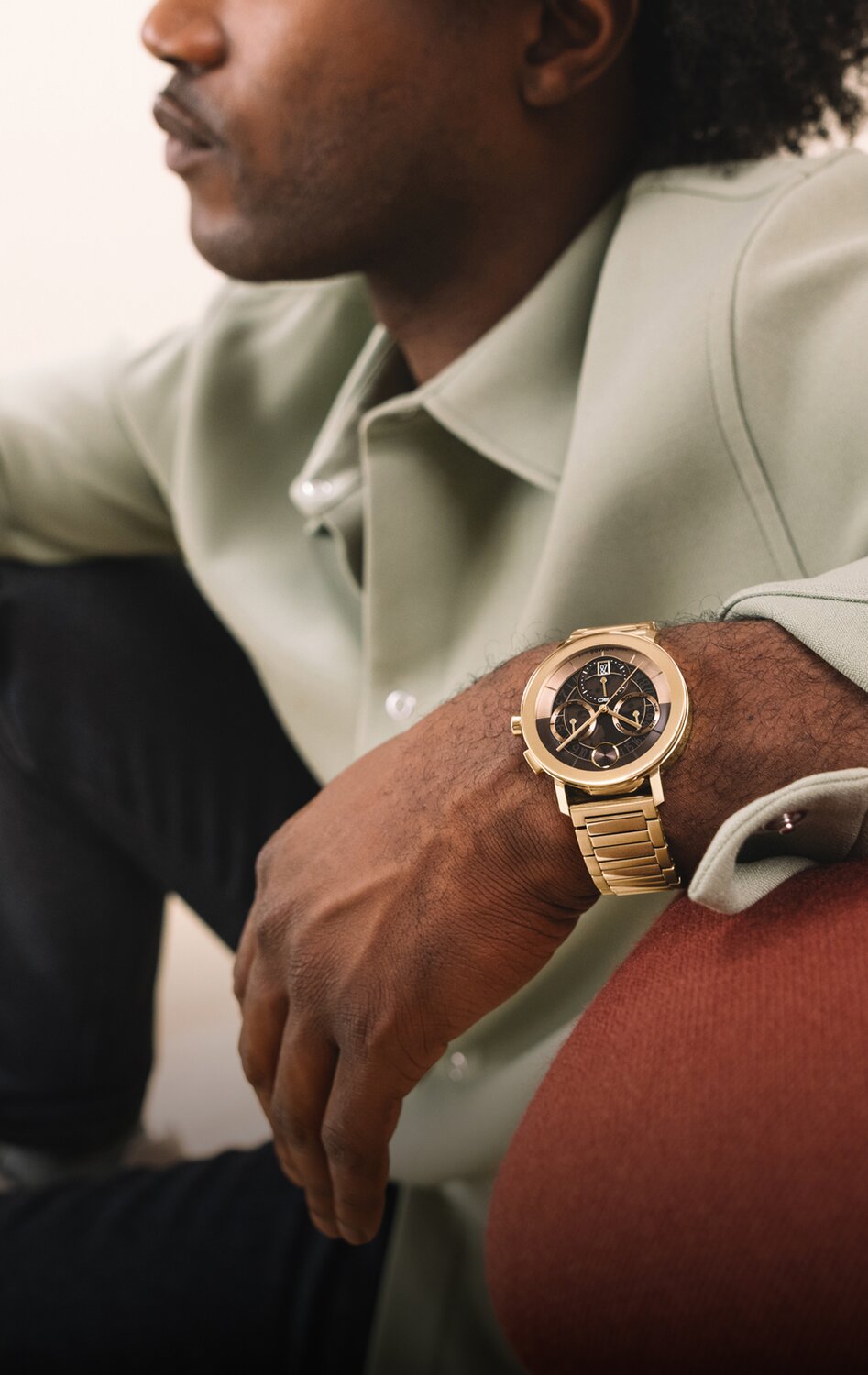 Man in button down wearing a BOLD Evolution 2.0 watch with gold tone bracelet and brown skeleton, chronograph dial. 