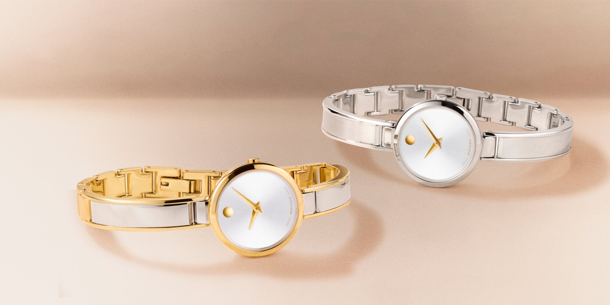 Two tone Moda bangle watch laying in front of a silver Moda bangle watch with gold accents