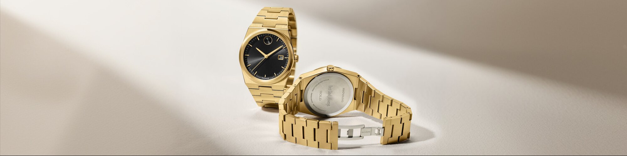 Front and back of a gold tone BOLD Quest bracelet watch with black dial. The caseback features personalized engraving that says, "Best Dad, Always".