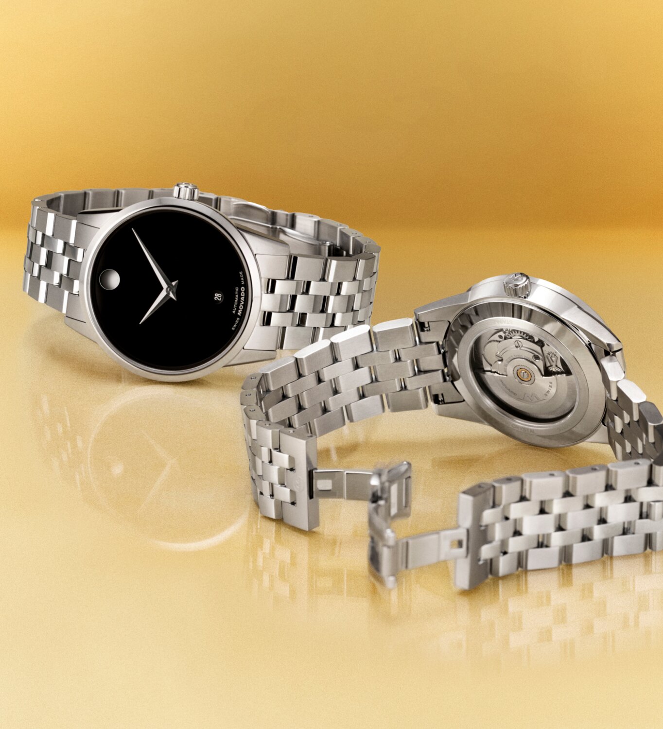 Museum Classic watch with silver bracelet watch and black dial next to the back of the watch with an exposed caseback