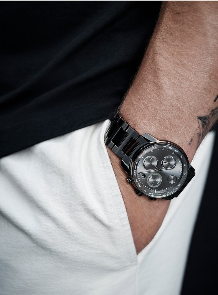 Christian McCaffrey's hand in the pocket of his white pants while wearing a grey BOLD Verso Chronograph watch