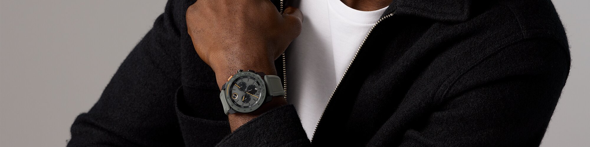 Man in a black jacket wearing a grey BOLD TR90 watch with rubber strap and black chronograph sub dials