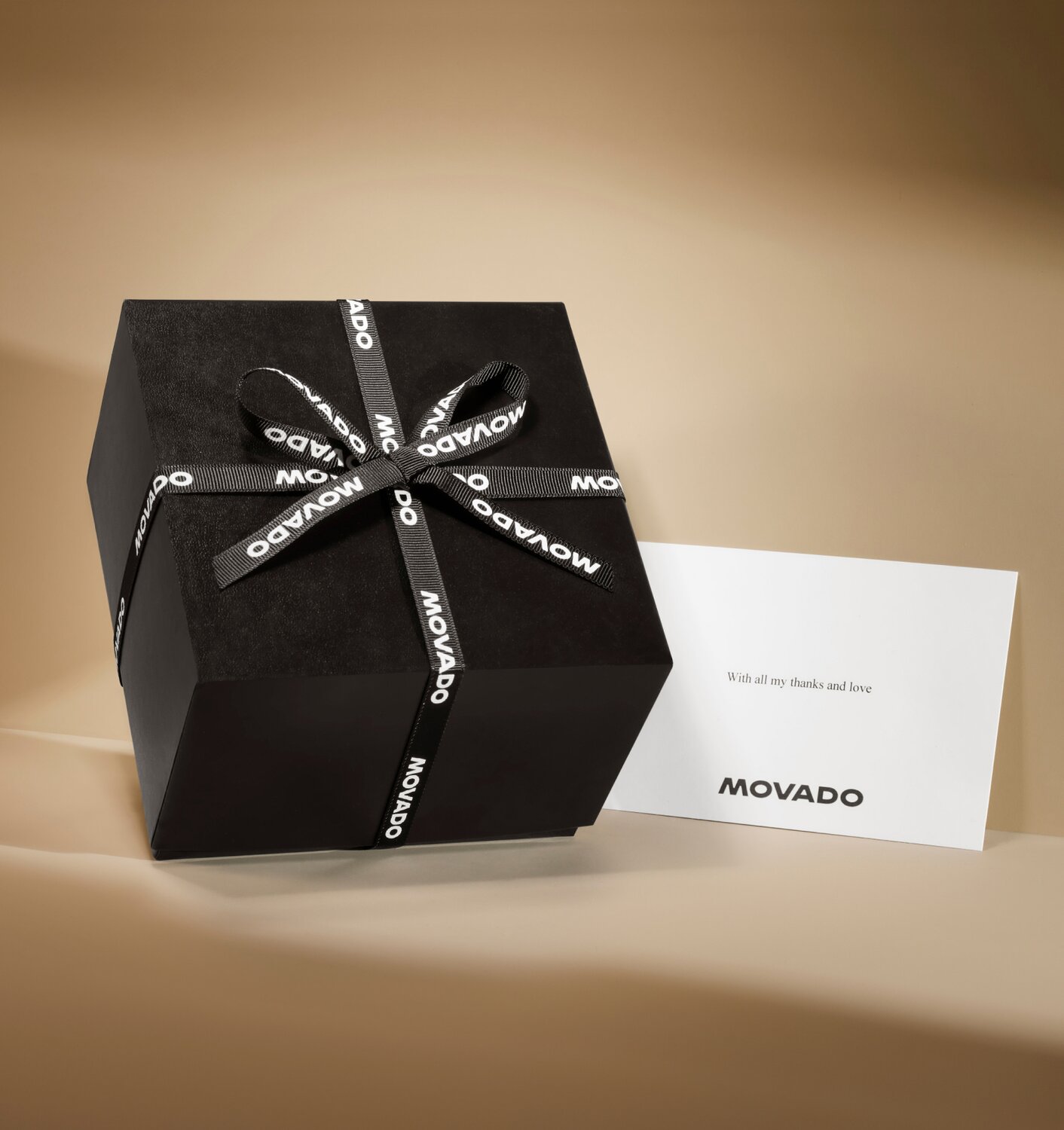 Movado black gift box with branded black ribbon and note card with Movado logo