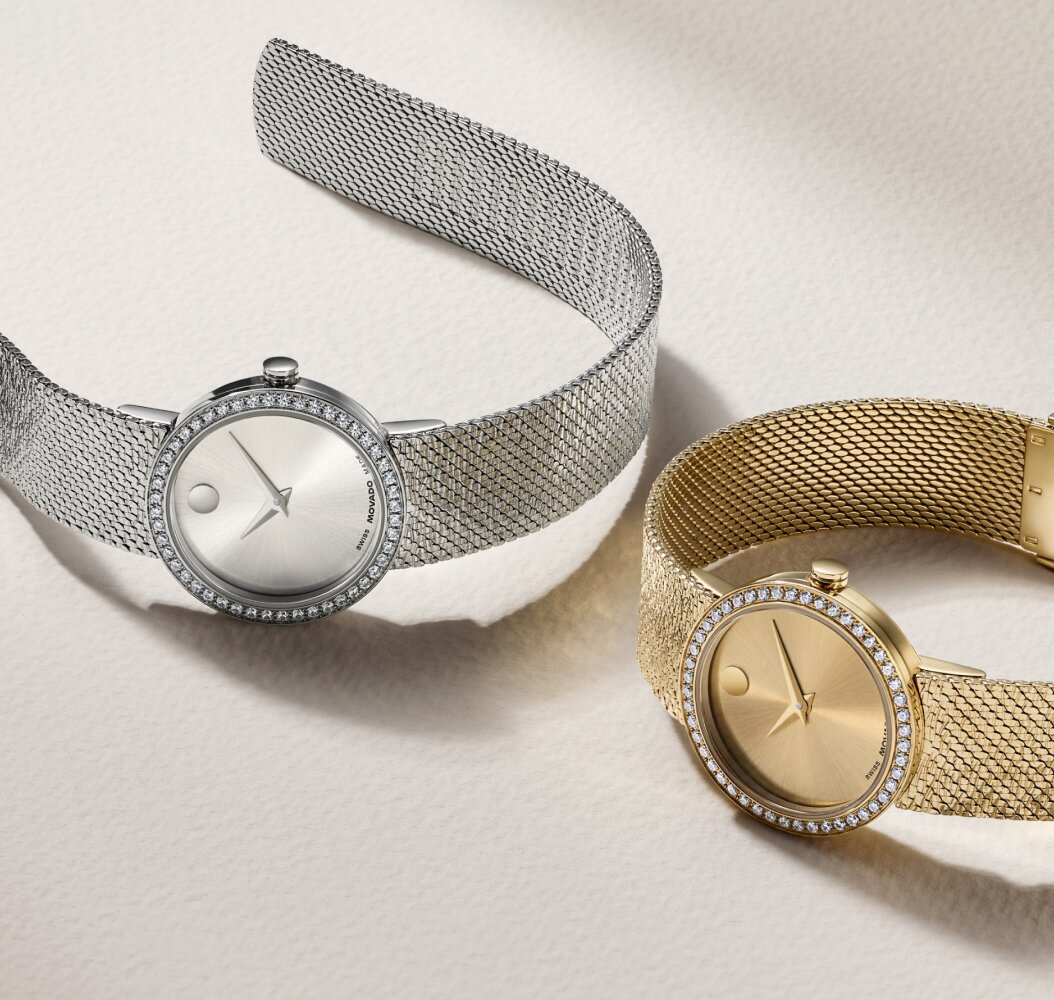 Stainless Steel Museum Velura mesh watch with lab grown diamond bezel laying next to a gold tone Museum Velura mesh watch with lab grown diamond bezel.