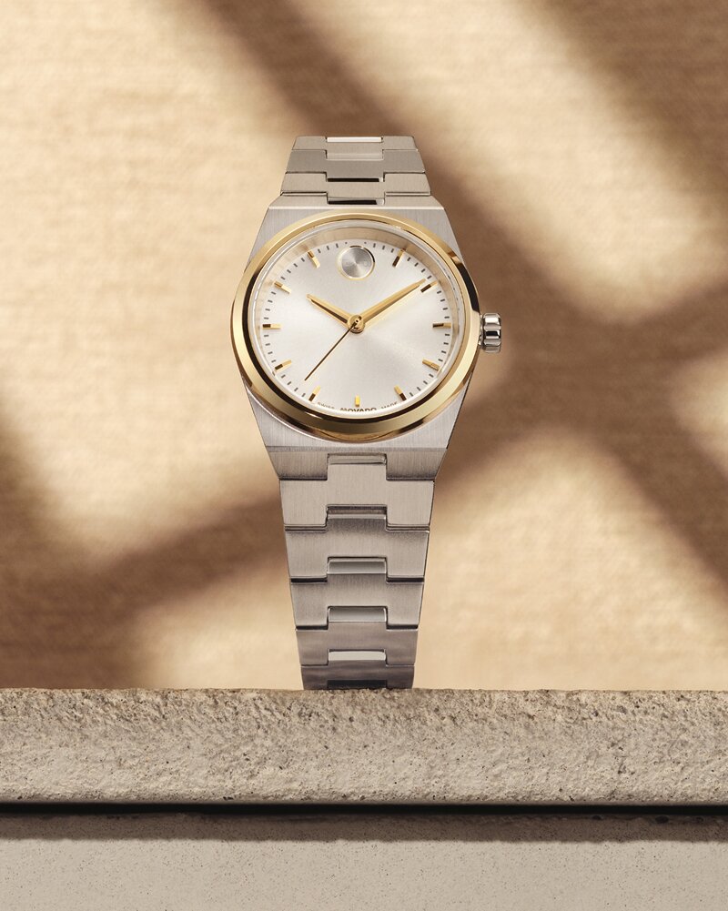 BOLD Quest Mini silver watch sitting on a stone slab in front of a tan wall