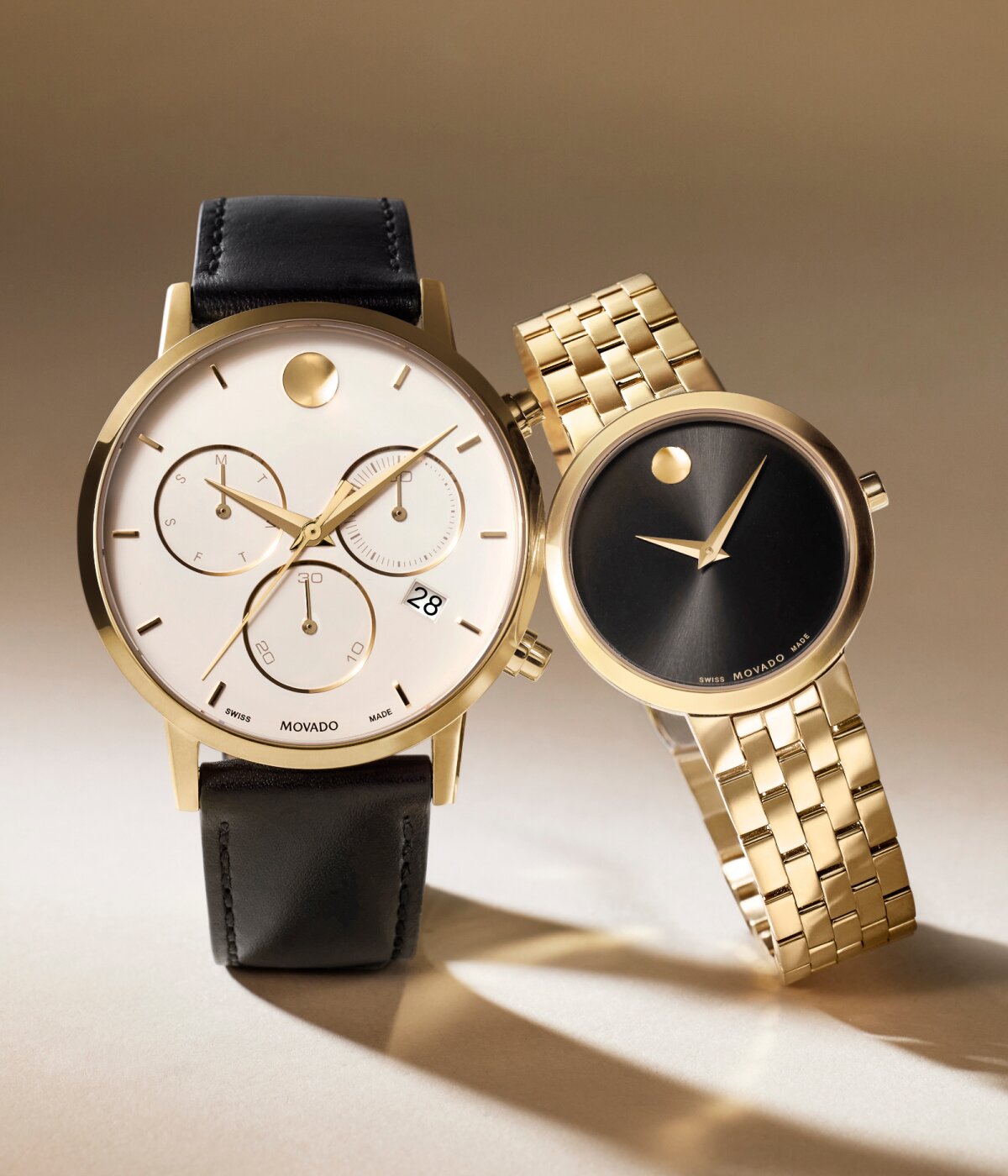 Museum Classic women's watch with gold plated bracelet and black dial next to a men's Museum Classic chronograph watch with black strap and white dial