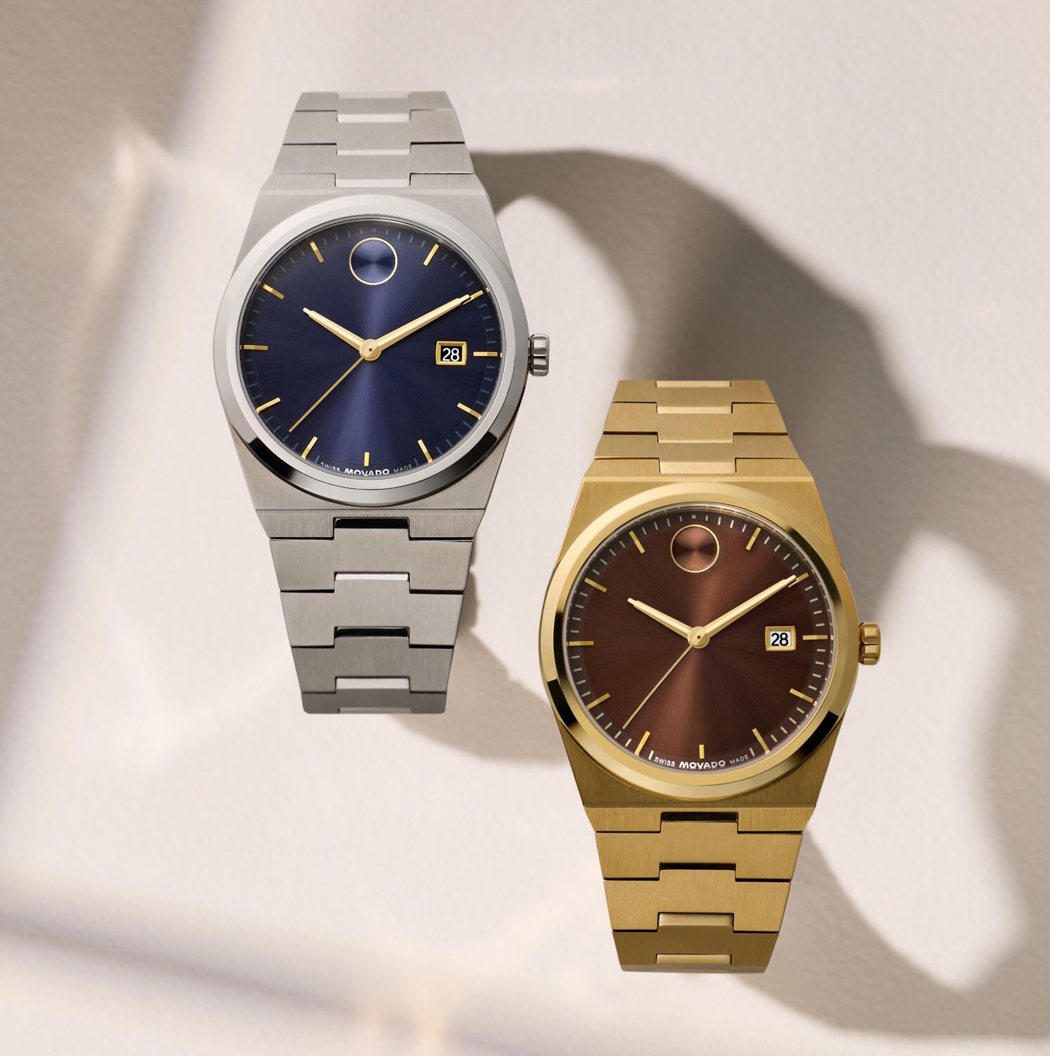BOLD Quest watch with stainless steel bracelet and blue dial next to another BOLD Quest watch with gold tone bracelet and brown dial.