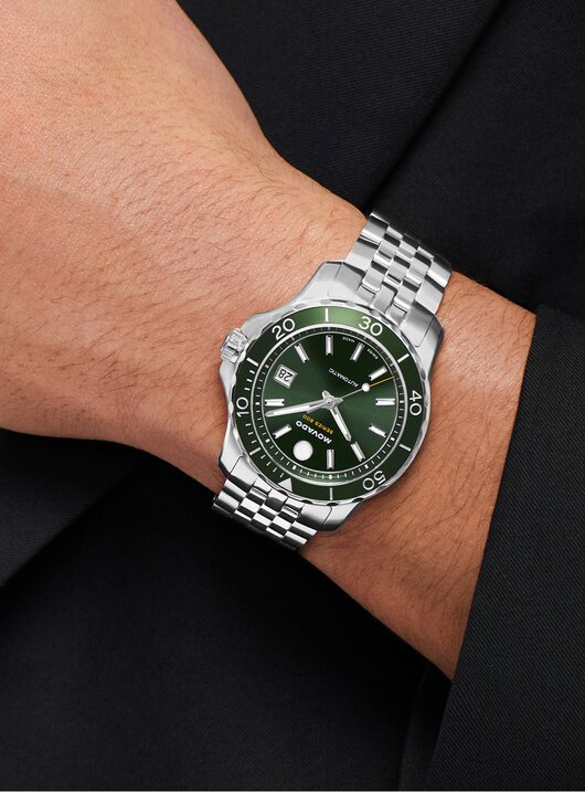 Man wearing the Series 800 stainless steel bracelet watch with green dial.