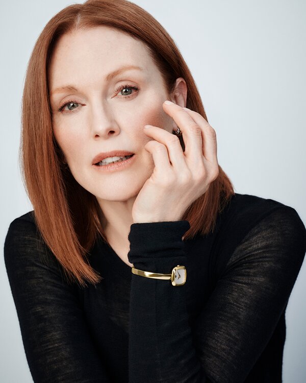 Julianne Moore in a black top wearing the gold tone Museum Bangle watch with square white dial.