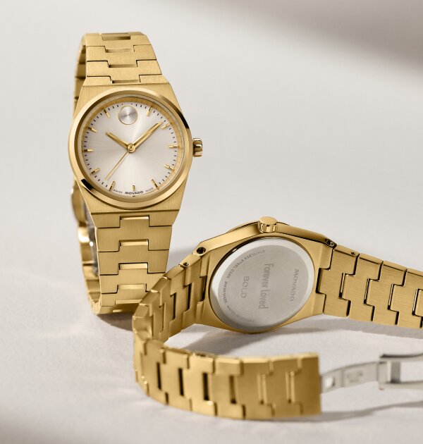 Front and back of a gold tone BOLD Quest Mini bracelet watch. The caseback features personalized engraving that says, "forever loved".
