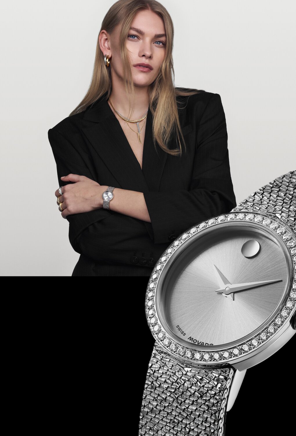 Woman in a black blazer wearing the stainless steel Museum Velura mesh bracelet watch with lab grown dial bezel.