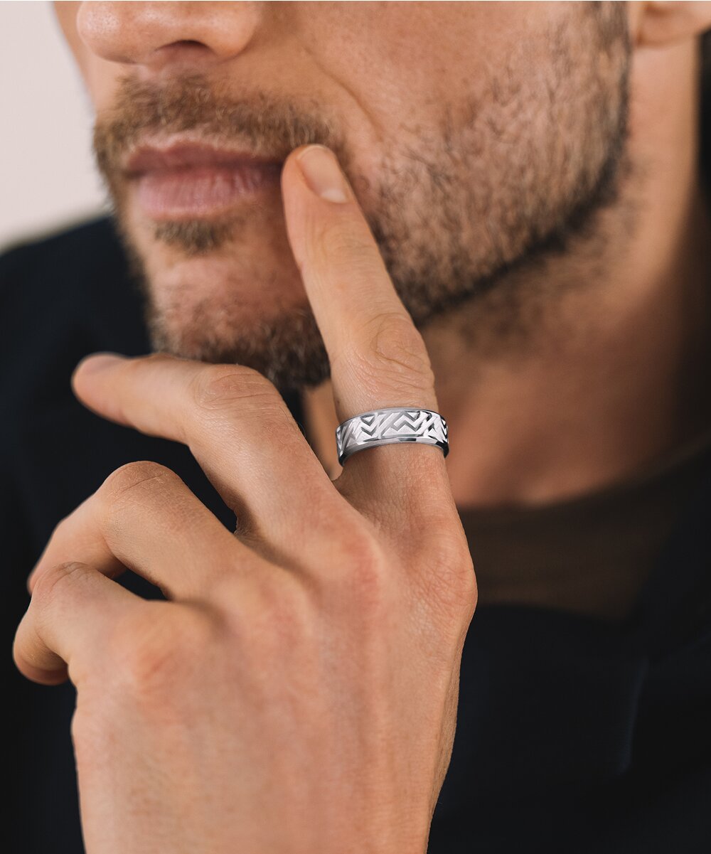 Man leaning on his hand wearing a silver ring.