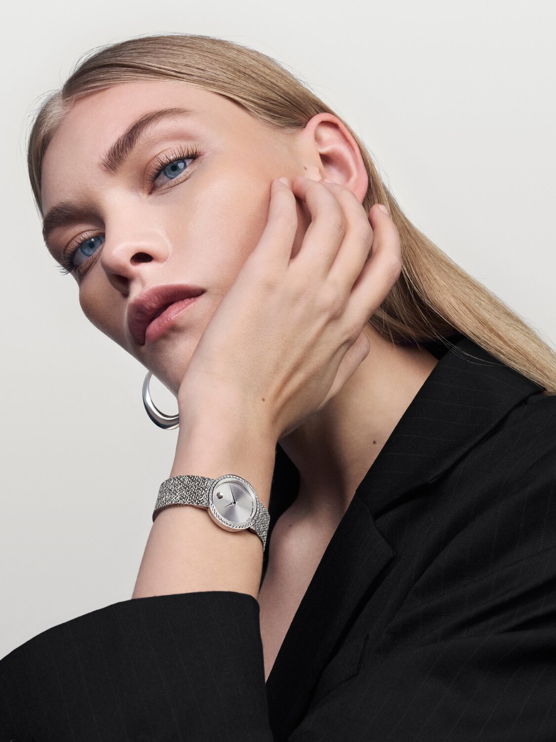 Woman in a black blazer wearing the stainless steel Museum Velura watch with mesh bracelet and lab grown diamond bezel.