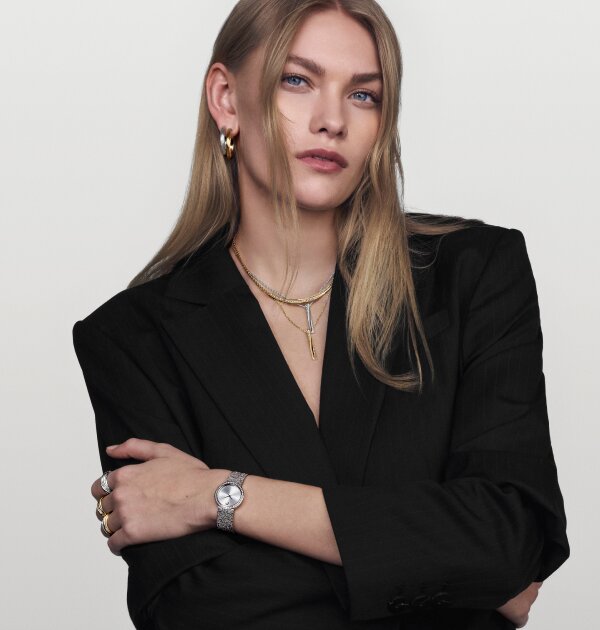 Woman wearing Movado rings, earrings and necklaces and the Museum Velura stainless steel watch with lab grown diamond bezel.