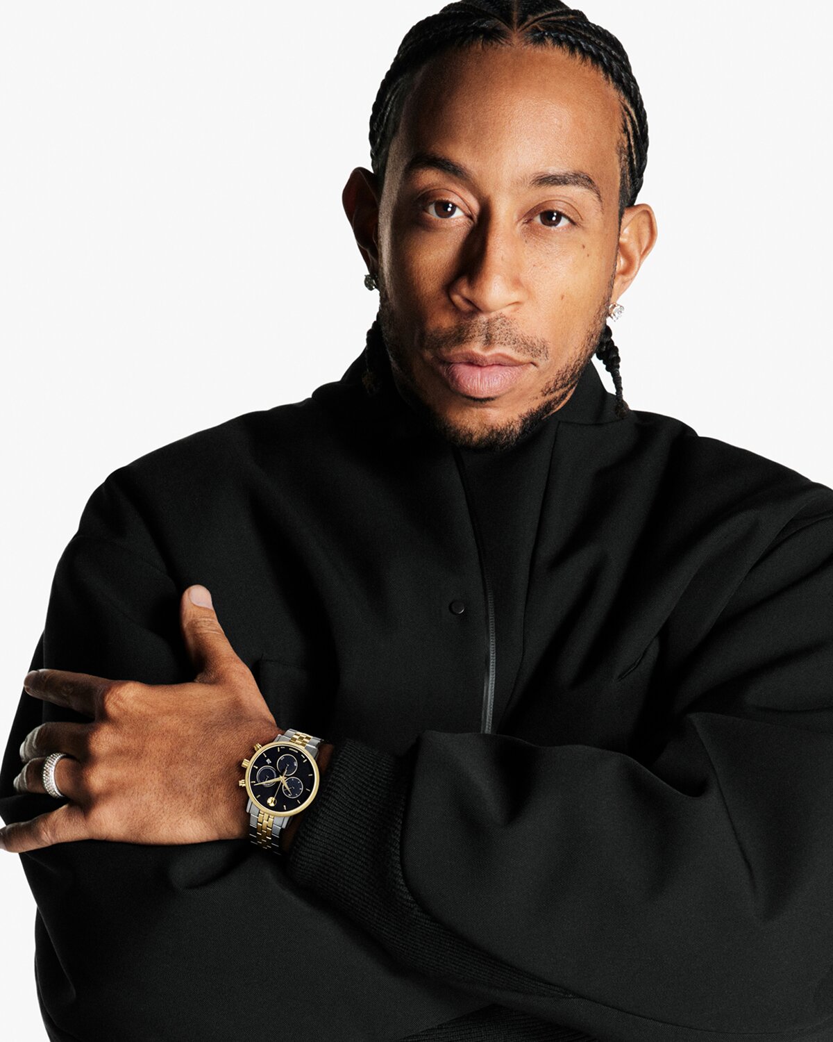 Ludacris in a black outfit wearing a Museum Classic watch with two tone bracelet and black chronograph dial.