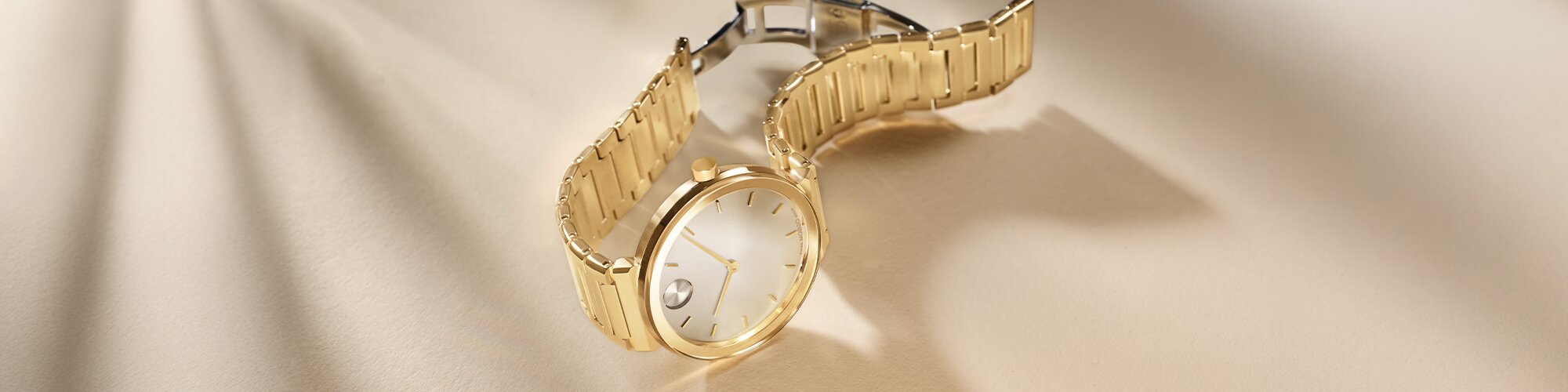 Gold tone BOLD Horizon bracelet watch laying on its side