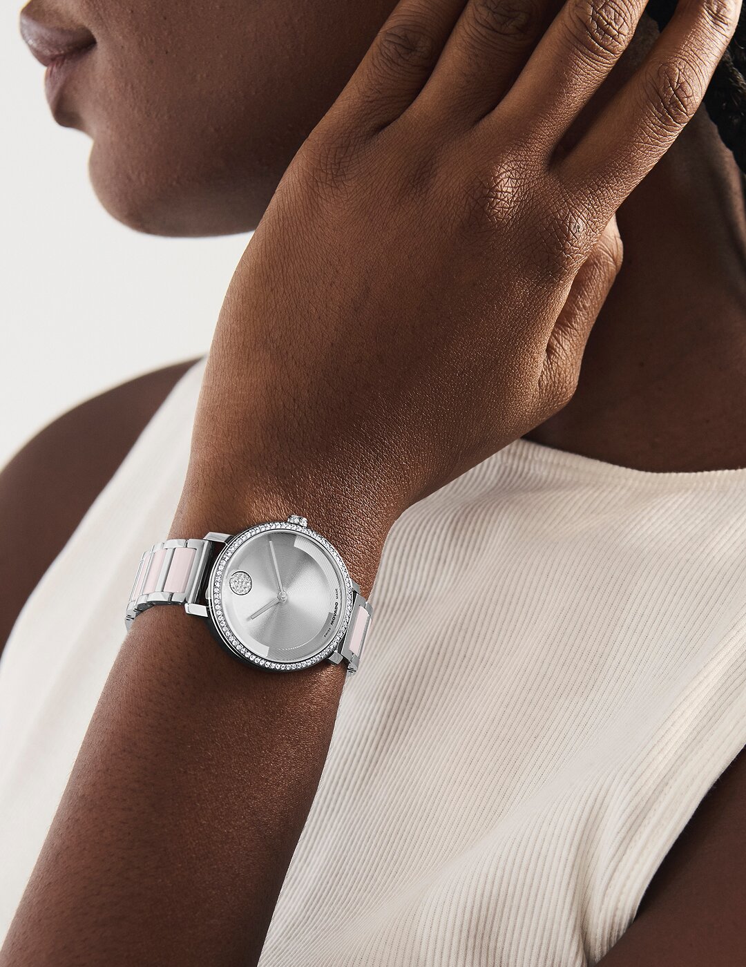 Woman wearing the stainless steel BOLD Evolution 2.0 bracelet watch with pink ceramic center links and crystal bezel.