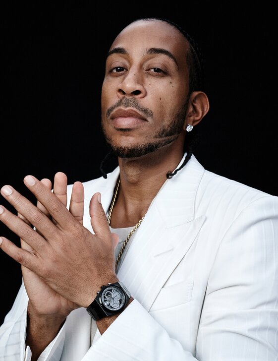 Ludacris in a white suit wearing a black BOLD Quest Skeleton watch