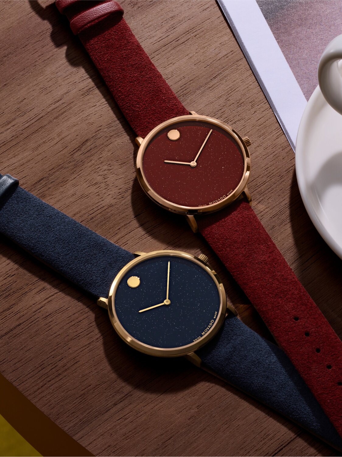 Blue Modern 47 watch and red Modern 47 watch laying down a table