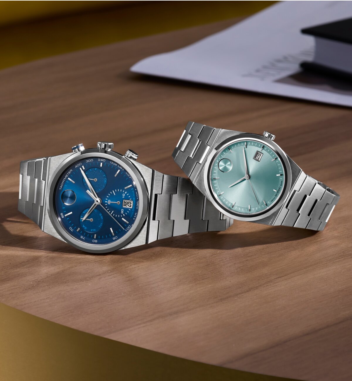 BOLD Quest chronograph watch with stainless steel bracelet and blue dial laying under a BOLD Quest stainless steel watch with light blue dial