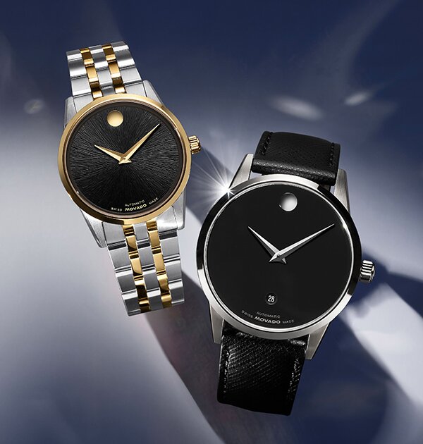 Museum Classic watch with black leather strap and black dial with silver accents next to a women's Museum Classic watch with two tone bracelet and black dial.