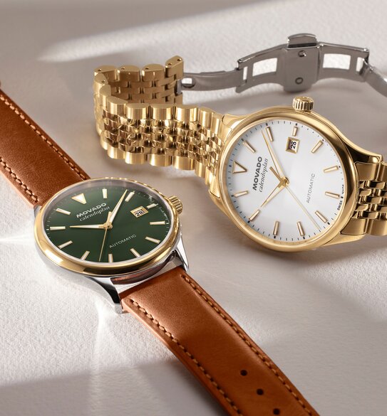 Heritage Calendoplan watch with brown leather strap and green dial next to the Heritage Calendoplan watch with gold tone bracelet and white dial.
